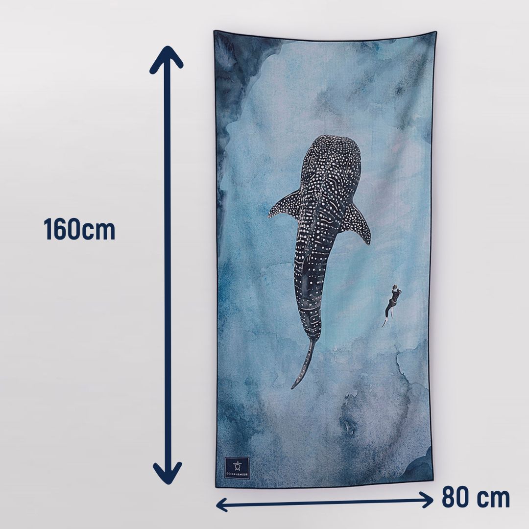 Size guide showing the Ocean Armour Whale Shark sand-free beach towel measuring 160 cm long by 80 cm wide. The microfiber towel features a blue ocean-inspired background with a large whale shark illustration and a diver, with arrows indicating the towel's dimensions.