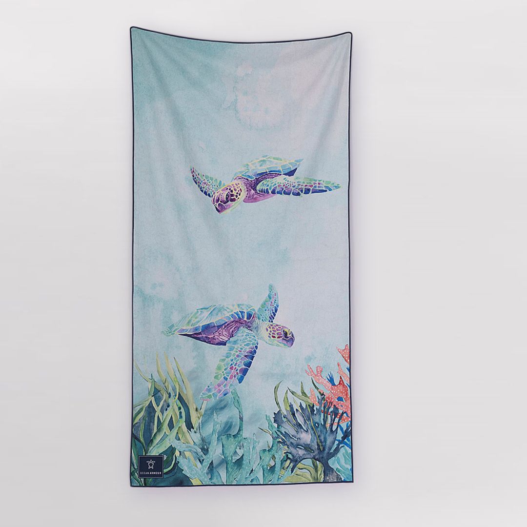 Ocean Armour Sand-Free Beach Towel featuring colorful sea turtle artwork with coral reef illustrations on a lightweight microfiber towel