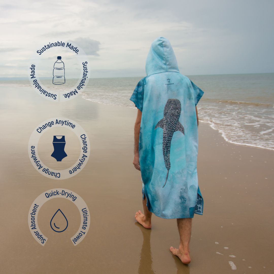 Back view of the Whale Shark Changing Poncho Towel with hood, featuring a large whale shark design. Icons indicate sustainable materials, quick-dry fabric, super absorbency, and roomy coverage for easy changing