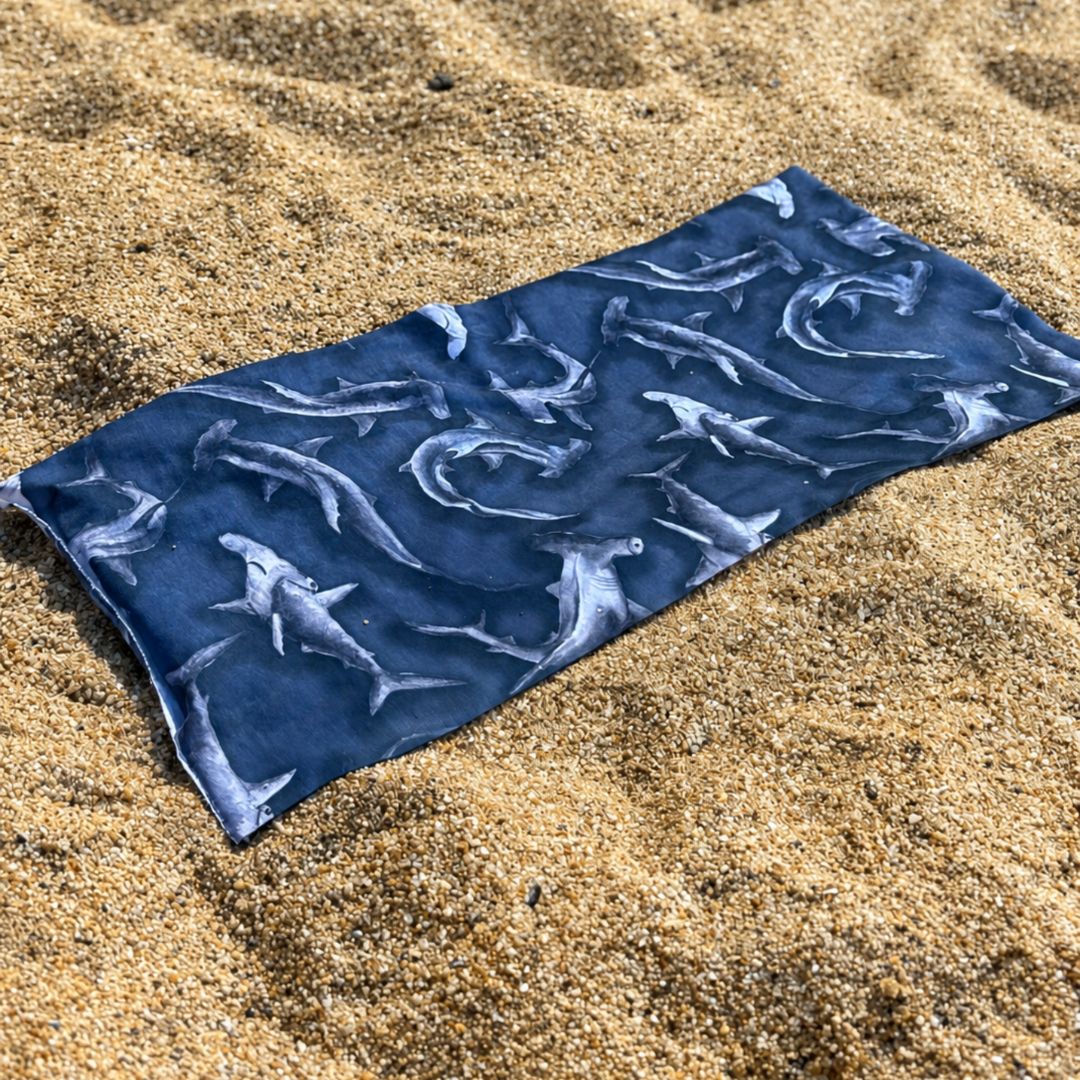 Blue fabric with shark pattern on a sandy surface