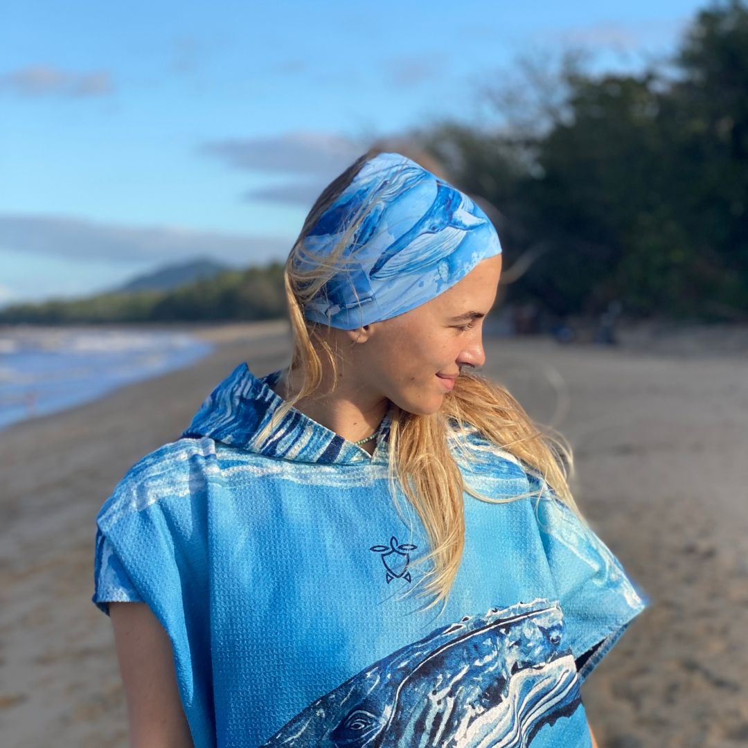 Person wearing a blue outfit with wave design on a beach